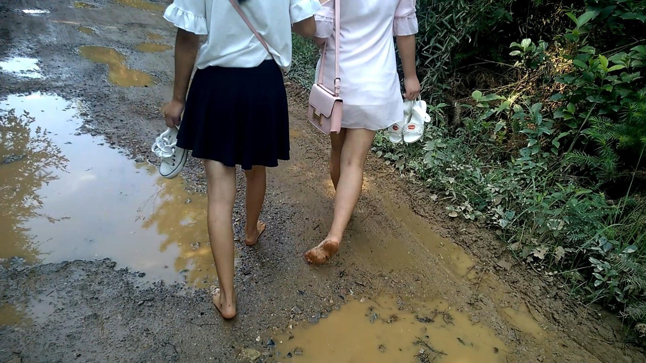 Cheng and Wei walked barefoot down the road, stepped into puddles left their feet covered in wet mud