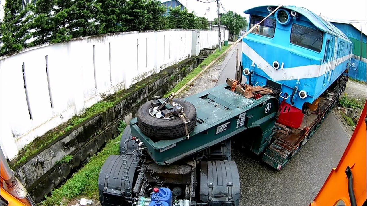 REAR VIEW VOLVO FMX 440 LOW LOADER. LEFT TURN REVERSE TO A NARROW ROUTE WITH CLASS 22 LOCOMOTIVE.