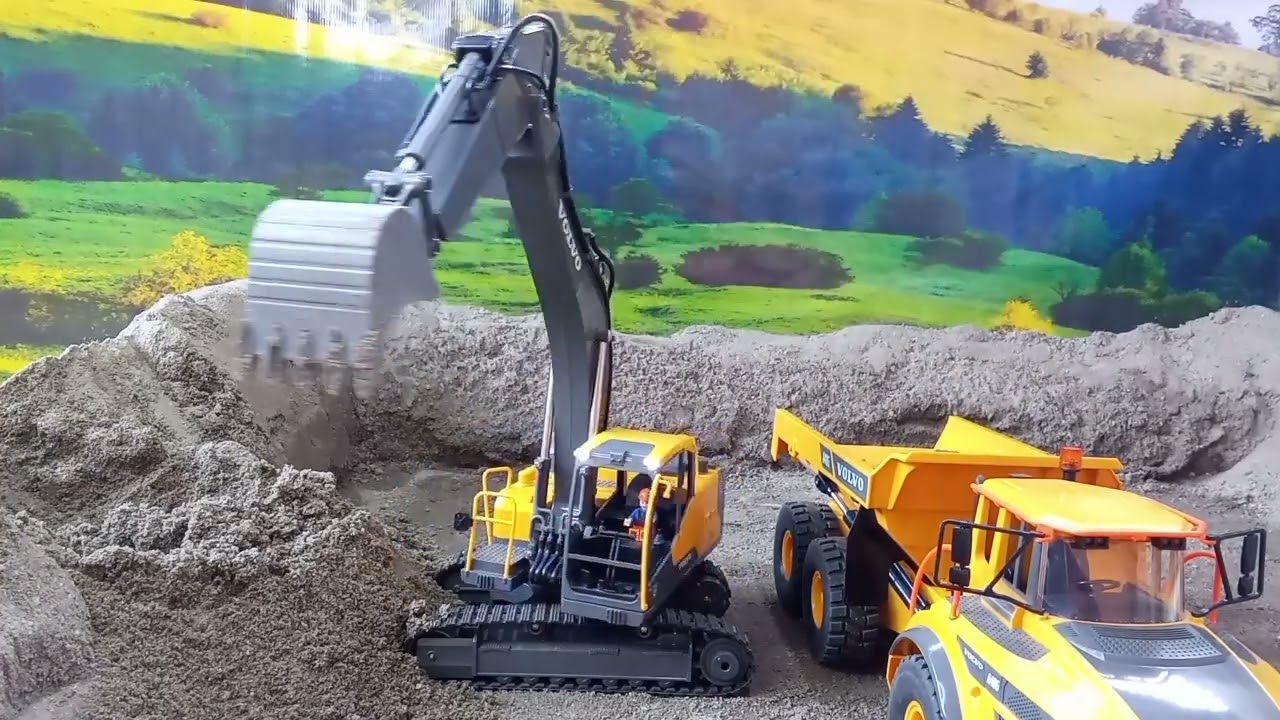 Rc excavator mines sand with rc dump truck at the mine site.