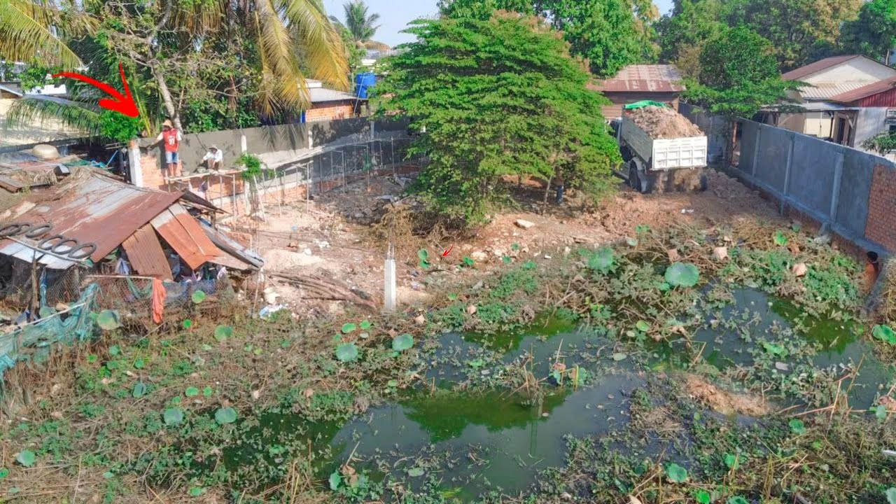 Complete successful landfill by skill bulldozer pouring dirt in fence with many trucks uploading