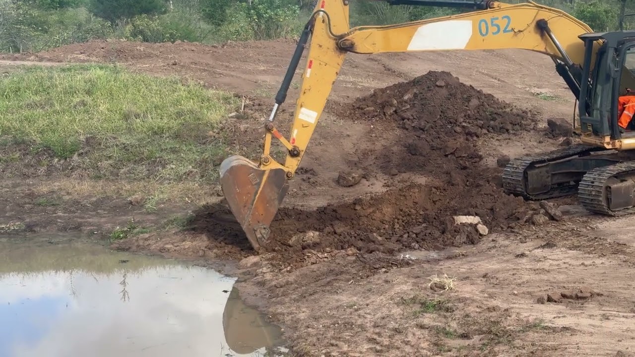 iniciando escavação de barragem com escavadeira hidráulica