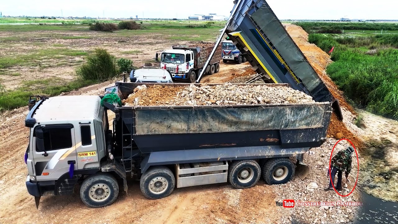 Nicely Landfill site in a large field By 25-ton Dump Trucks Dumping Soil & Skills Dozer Pushing Soil