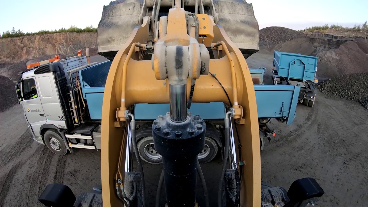 a day at work Caterpillar 972M XE wheel loaders loads truck and dumpers