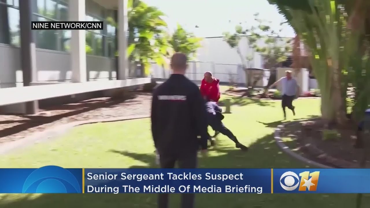 Senior Sergeant Tackles Suspect During Media Briefing
