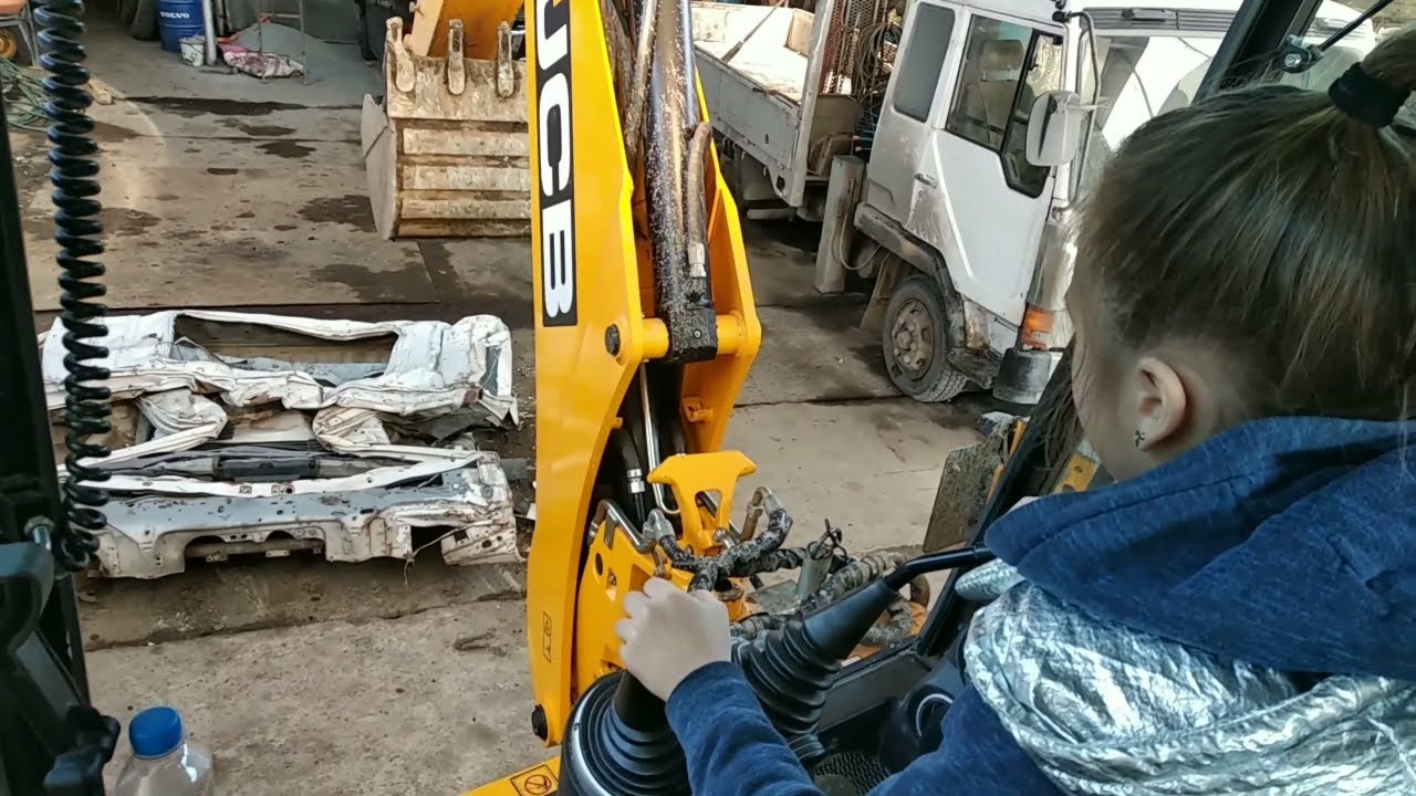 Girl drives an excavator loader JCB 3CX