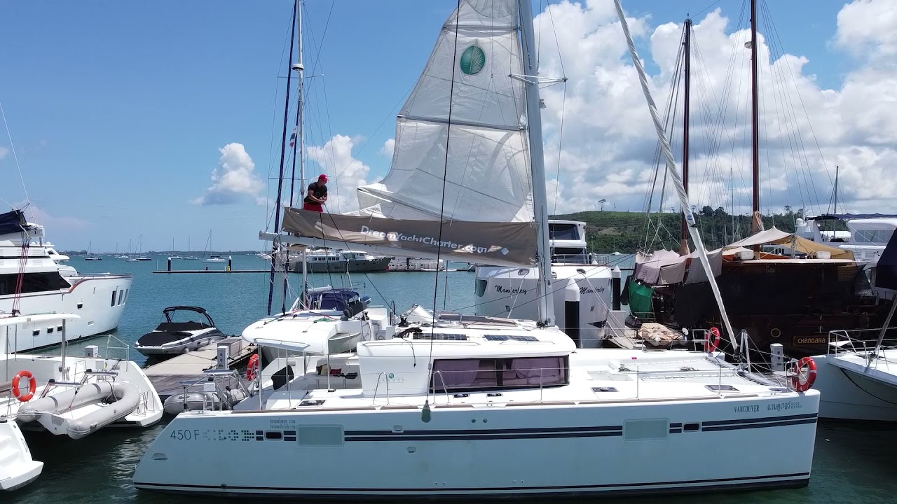 Folding the sails of the sailing catamaran Lagoon 45 by one man