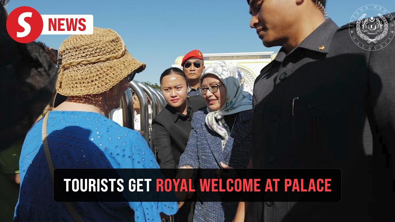Queen greets tourists at entrance to Istana Negara