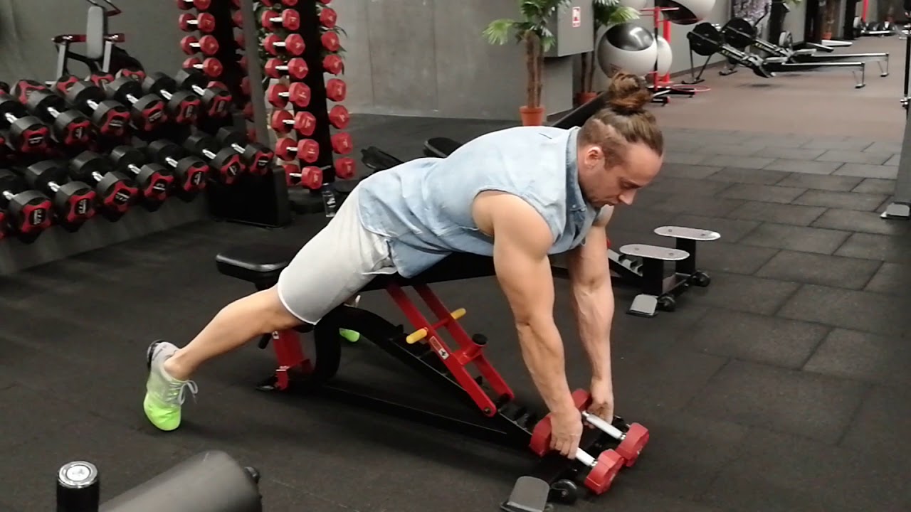 Mostai su hanteliais į šalis gulint ant pilvo