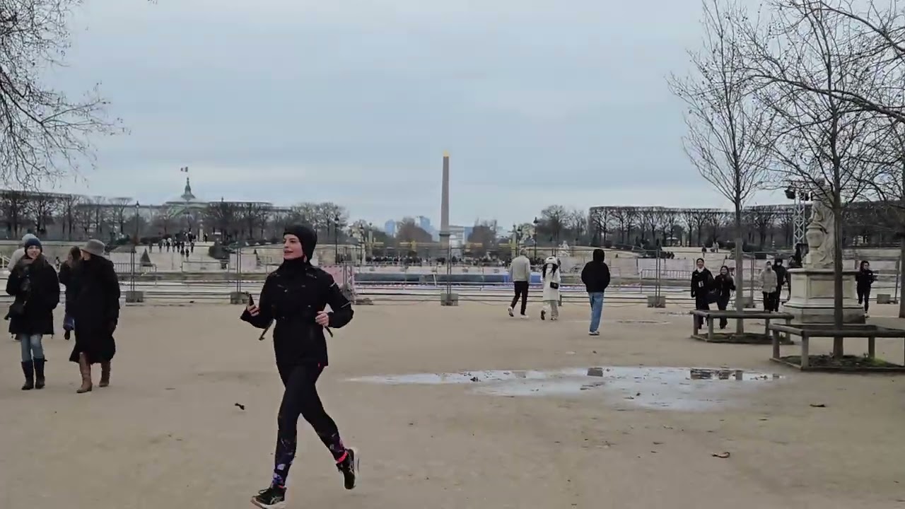 Walking along Park Tuileries in Paris with view of Eiffel Tower in winter
