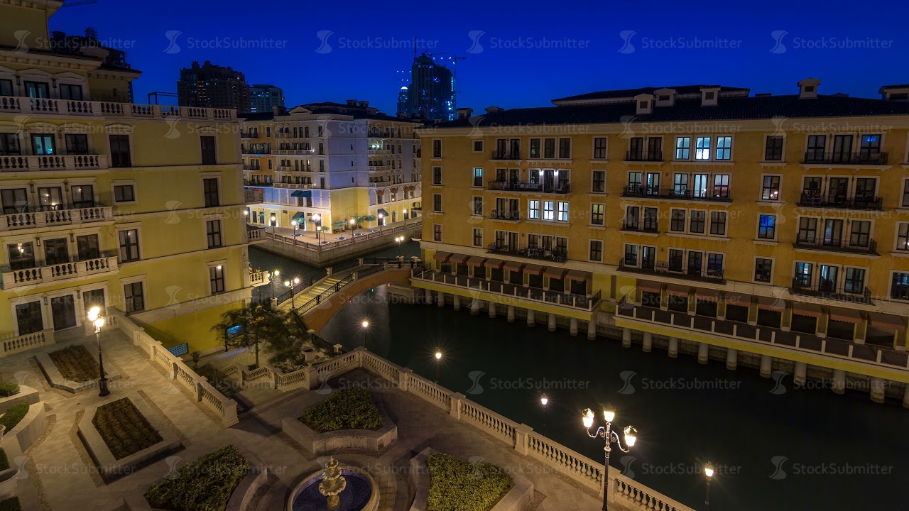 Canal aerial top view in Venice-like Qanat Quartier of the Pearl precinct of Doha day to night