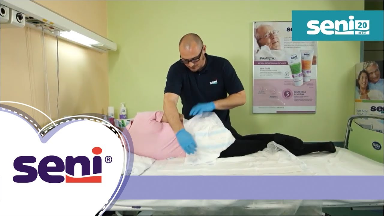 Aplicarea scutecelor Seni cu sistem inchis pe o persoana imobilizata