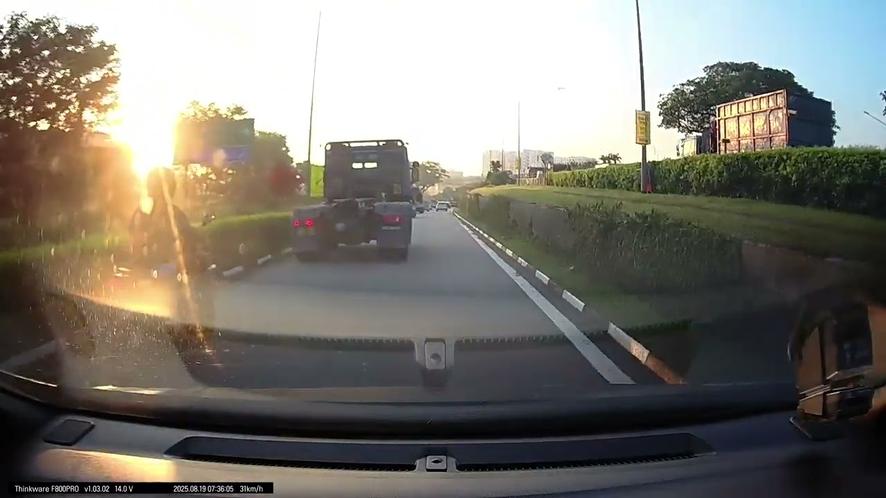 Malaysian motorcycle overtaking from road shoulder and dangerously switching lanes