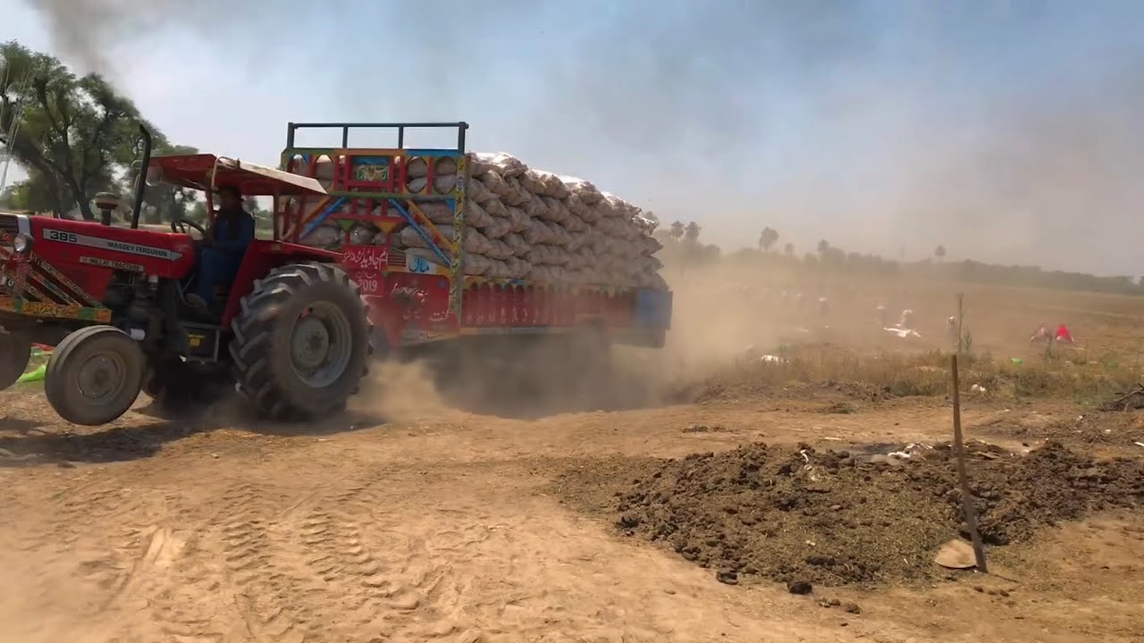MF 385 pulling heavy loaded 18ft trolley