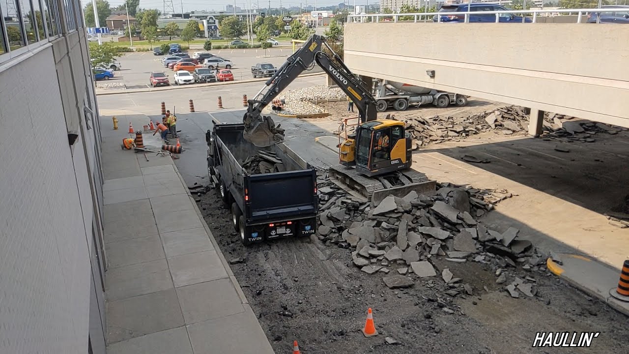 Overhead View of Excavator Loading Broken Asphalt into Dump Truck