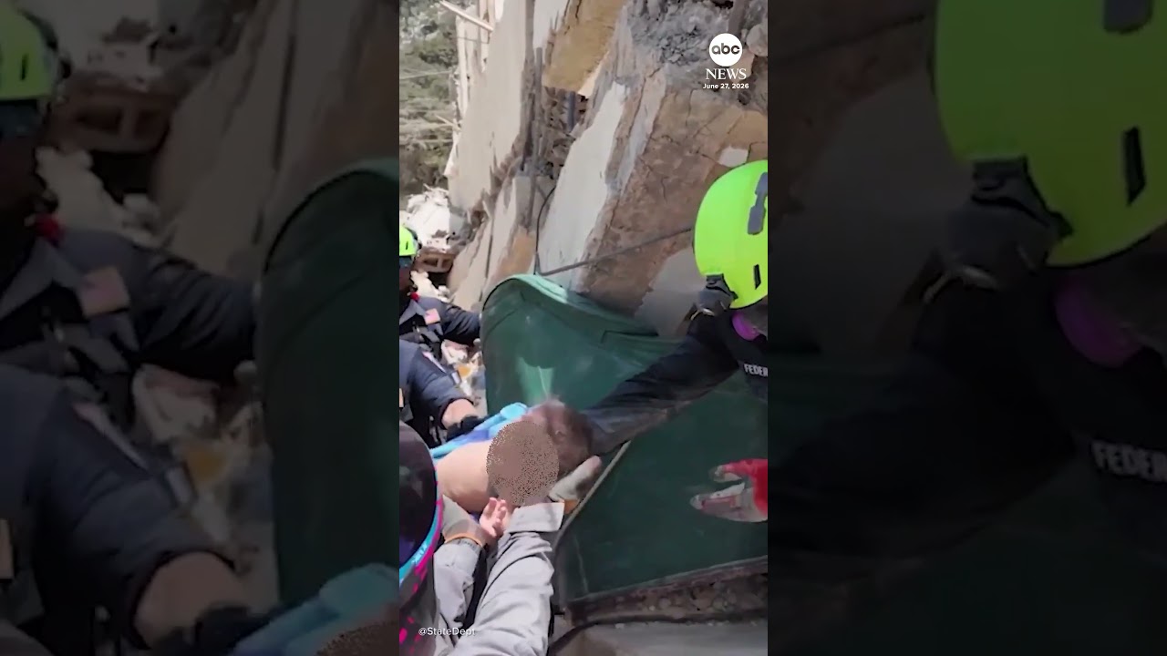 Американские спасательные команды помогают извлечь младенца и мать из-под завалов после землетряс...
