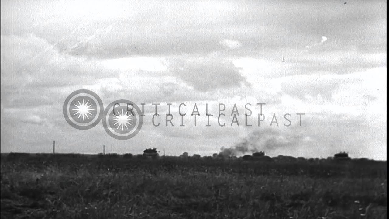 British soldiers follow tanks advancing; Shermans fire and enter a village in Fra...HD Stock Footage