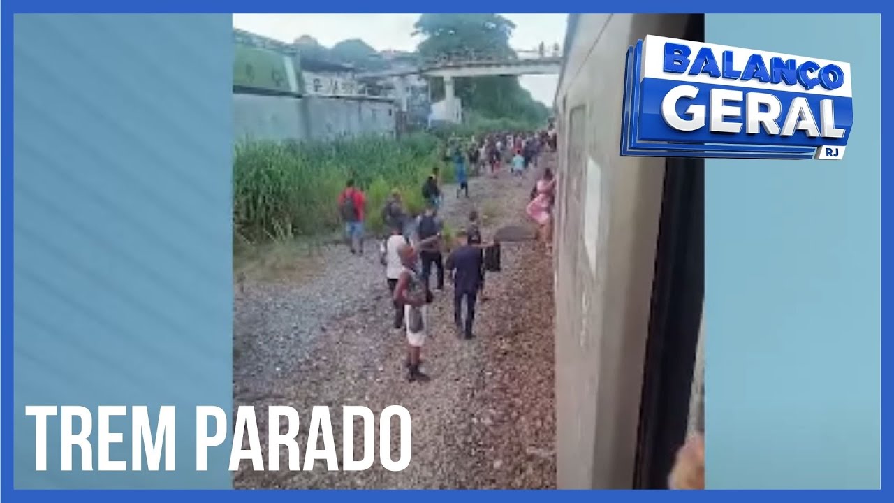 TREM PARADO E PASSAGEIROS ANDAM NOS TRILHOS