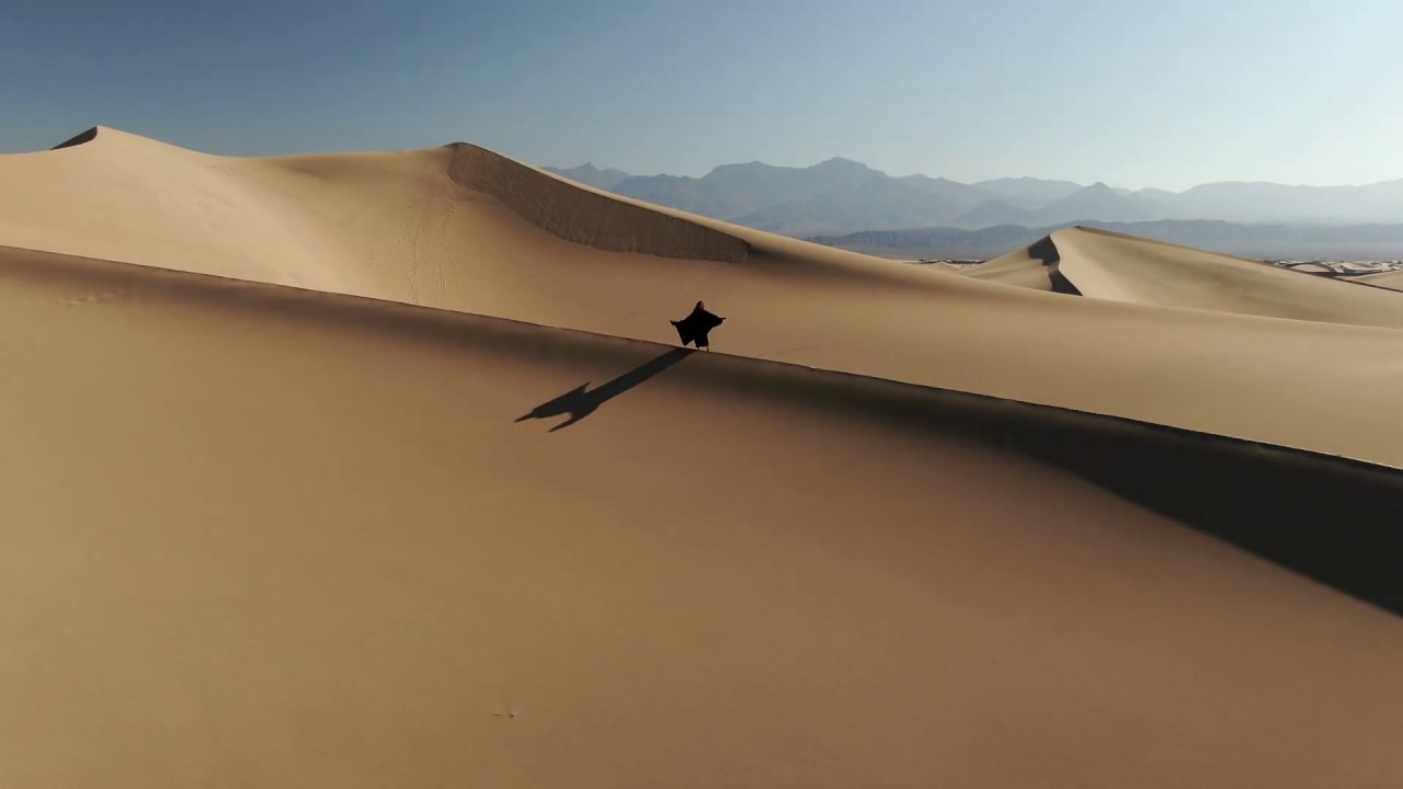 Woman walking at desert sand dunes. ( Copyright )