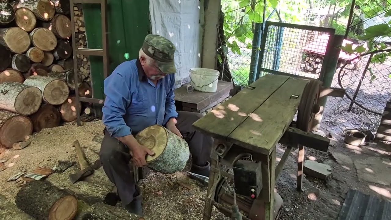 Дід сидячи коле дрова