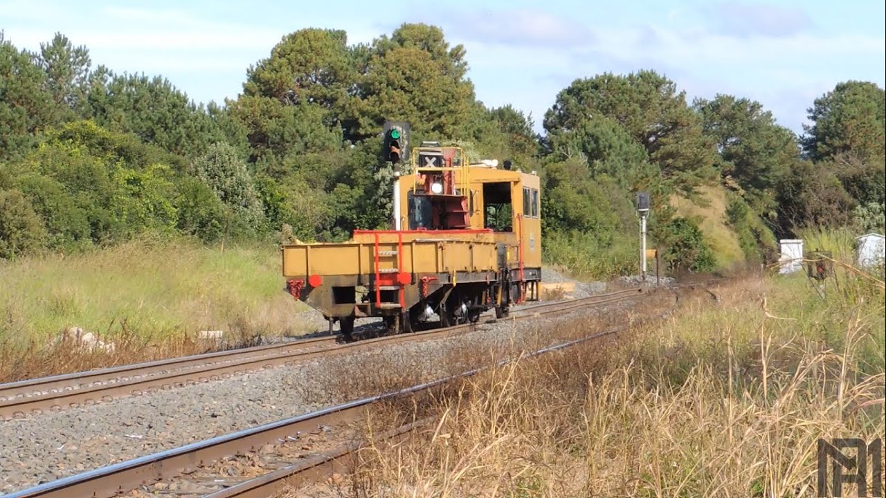 Auto de linha cruzando com um trem vazio