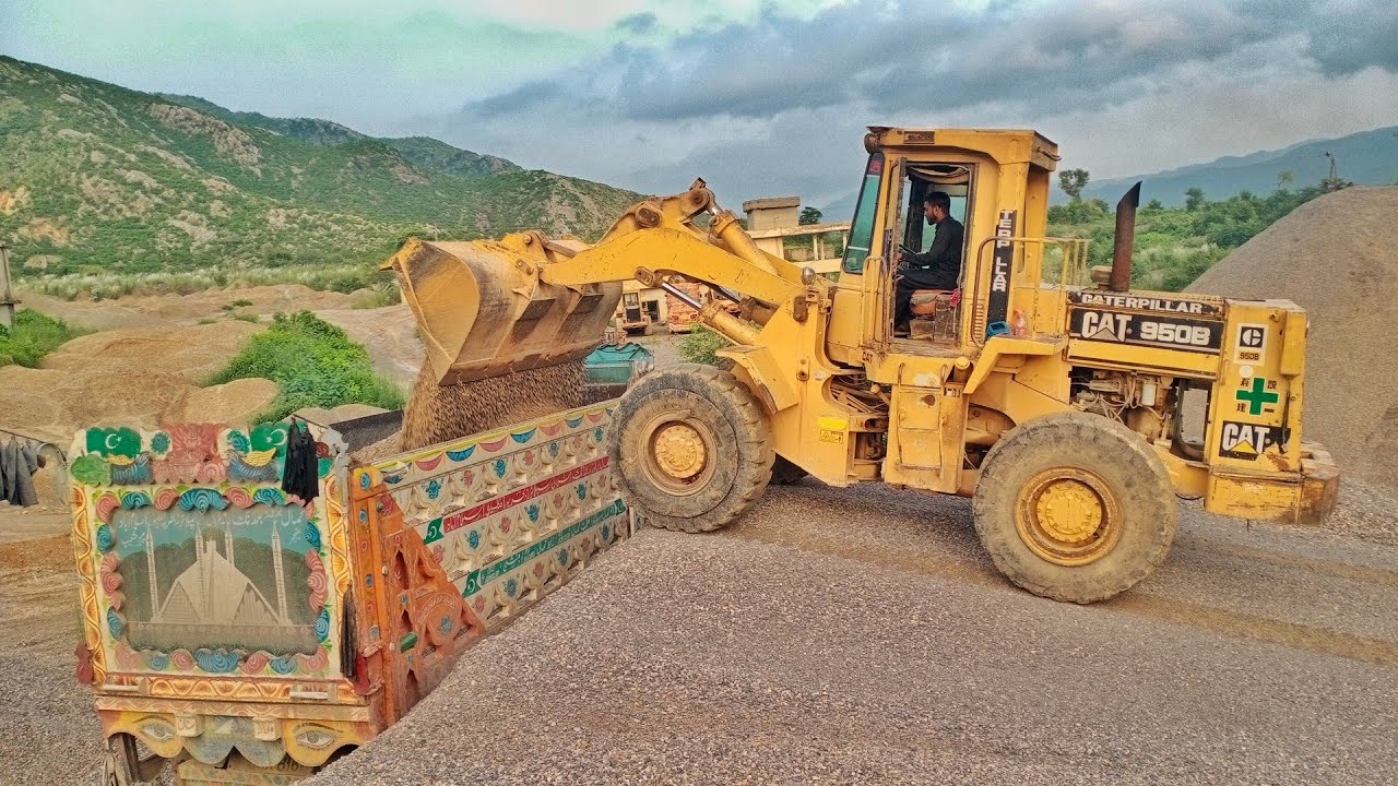 Caterpillar wheel loader 950B is loading dumper with stone crush 