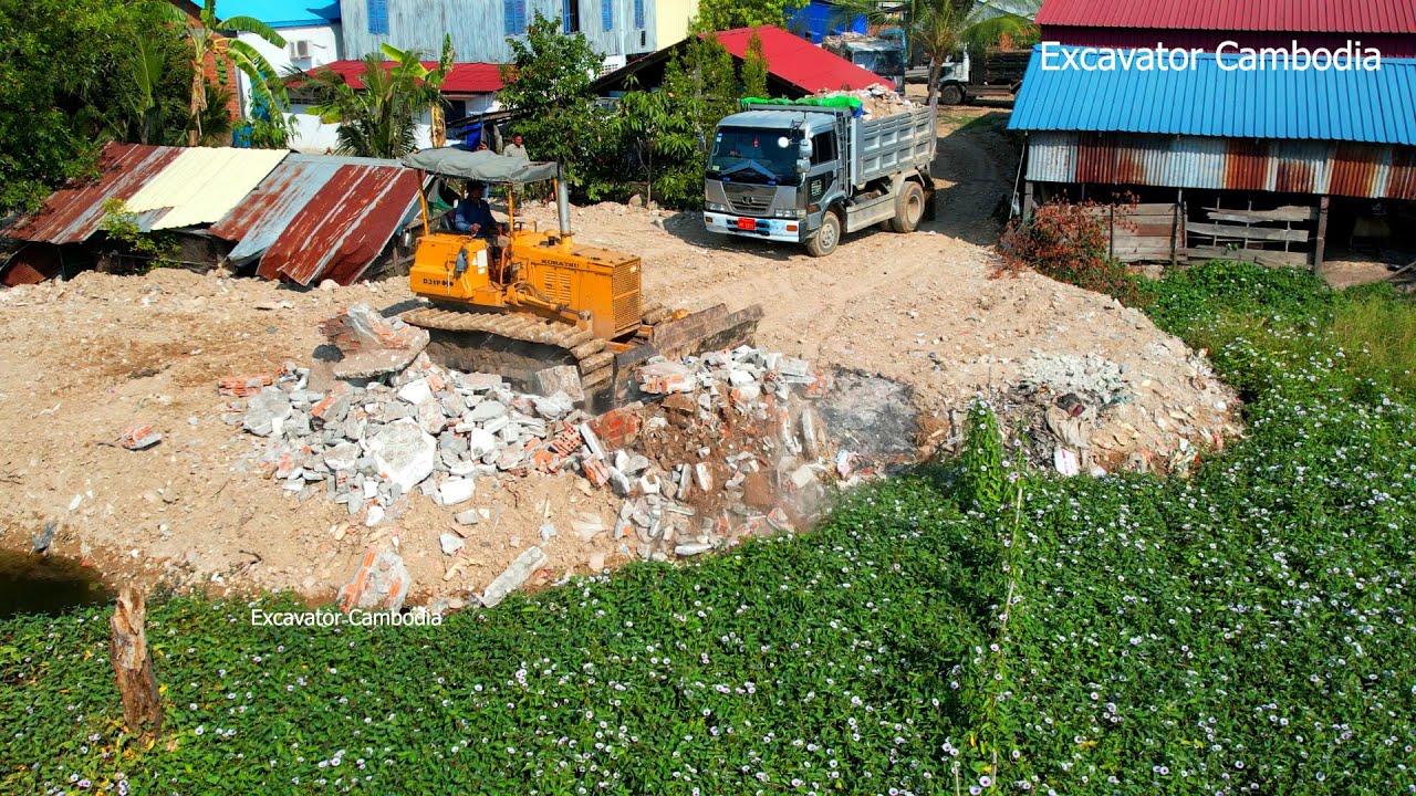 Komatsu Dozer Made In japan Pushing Rock And Dump Truck Made In Korea Unloading Rock Filling Forest