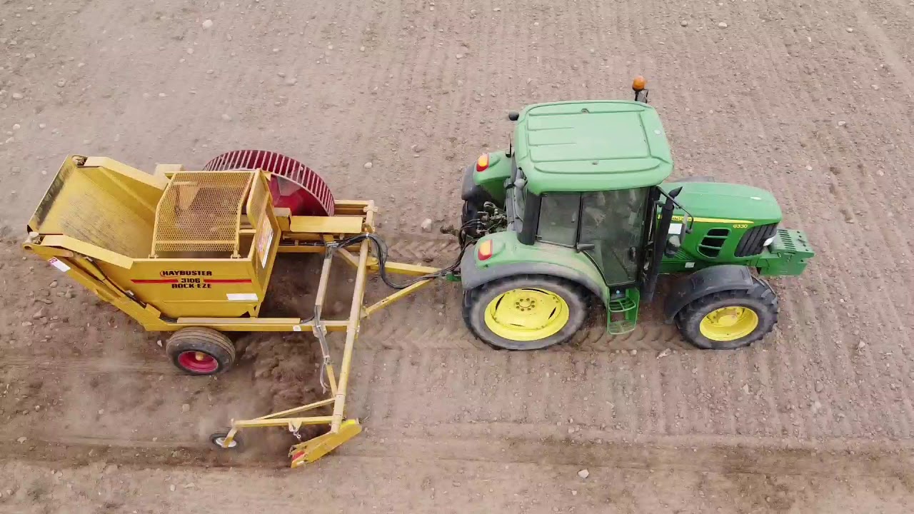 Pokaz zbieracza do kamieni Haybuster RockEze 3106. John Deere 6330