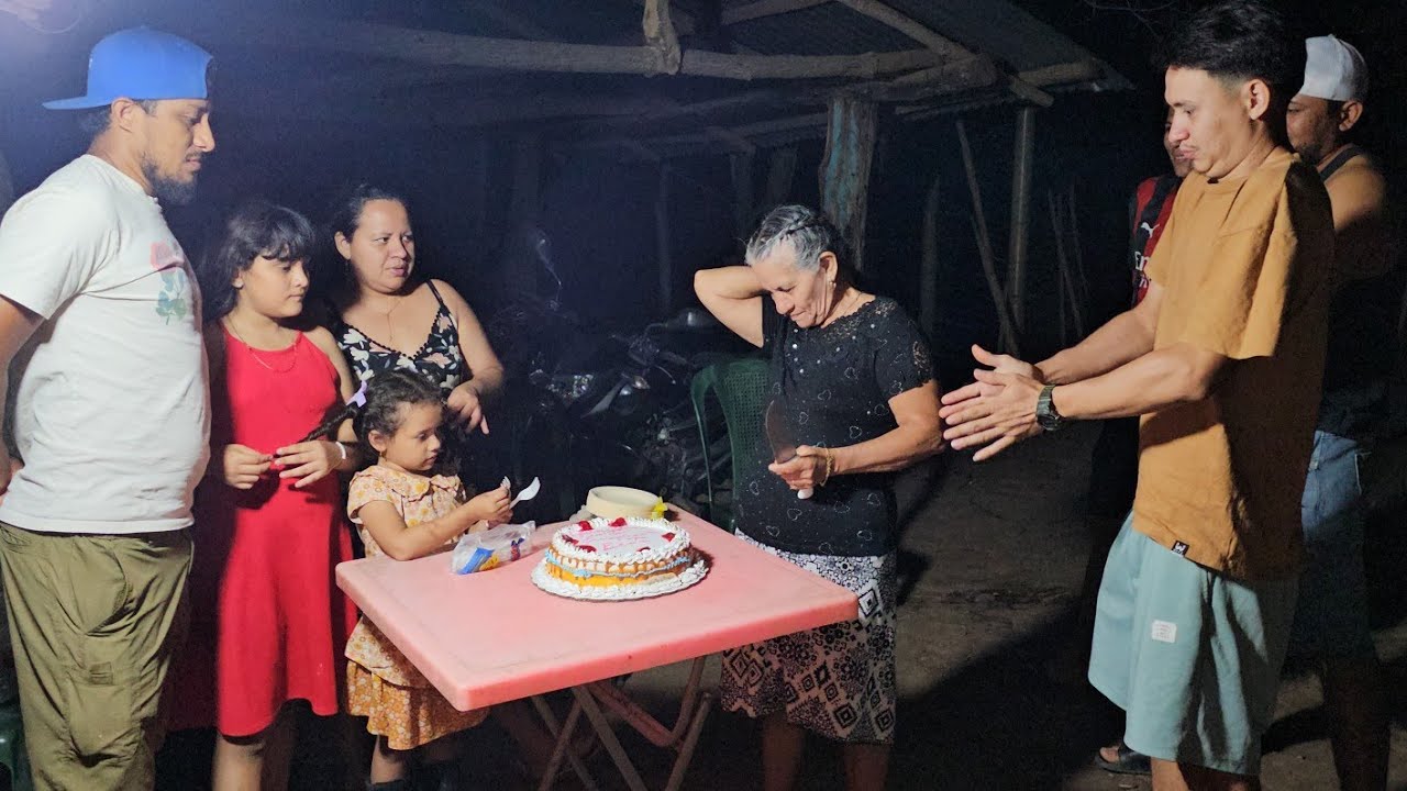 Un hijo es el patrocinador del cumpleaños partiendo el pastel 