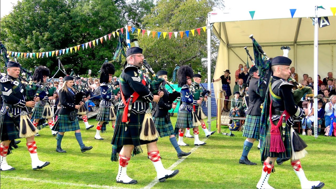Combined Pipe Bands lead Lonach Highlanders afternoon march during 2024 Lonach Gathering and Games