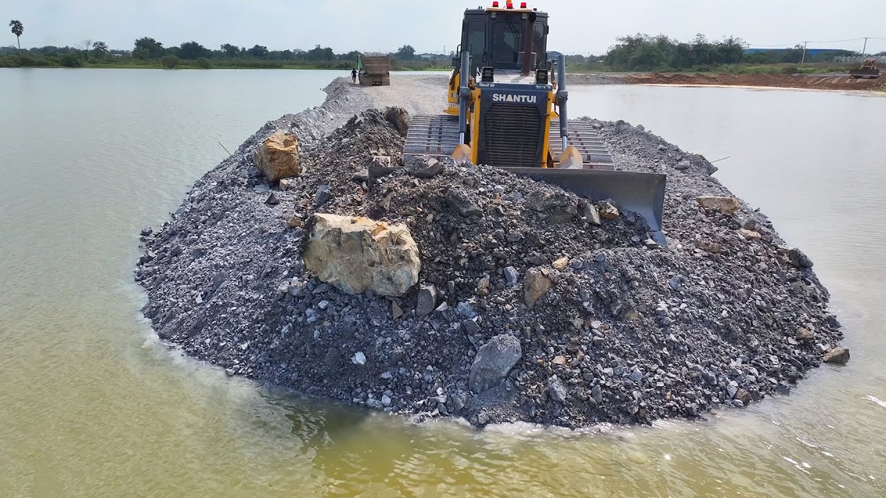 New road paving project with a big bulldozer and a 25-ton truck carrying paving stones