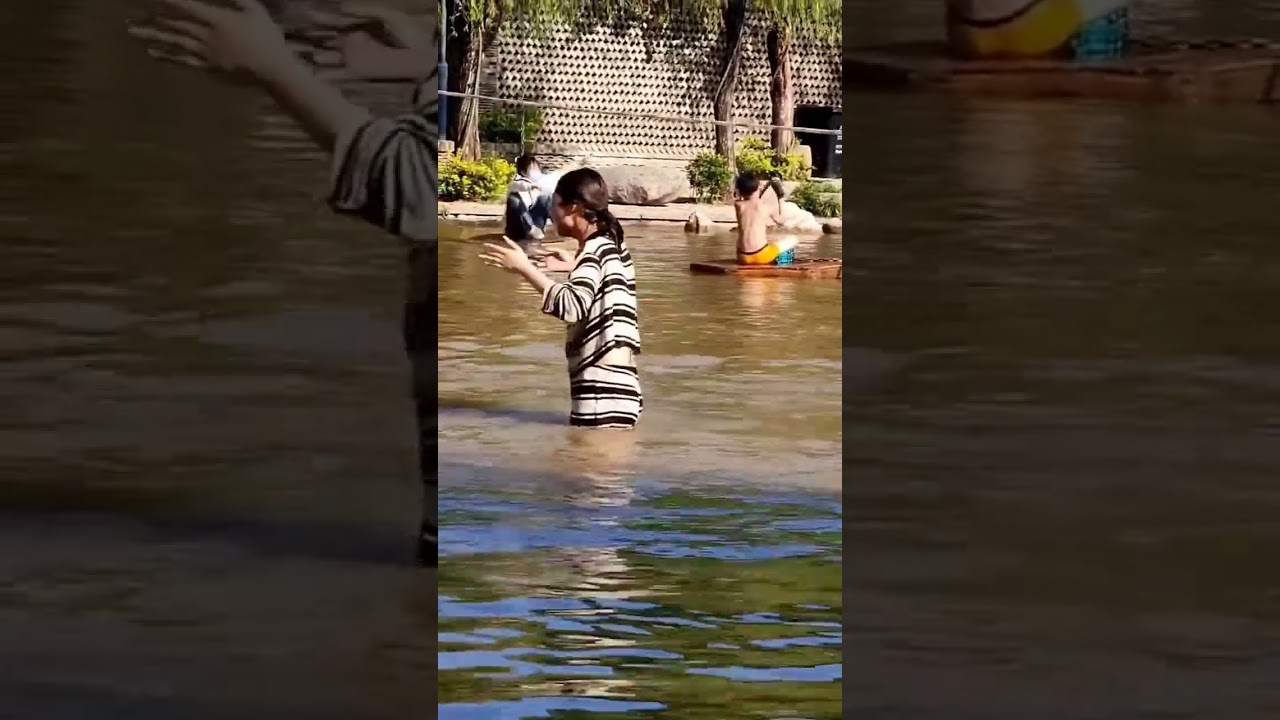Two Chinese woman wet boots playing slings on water