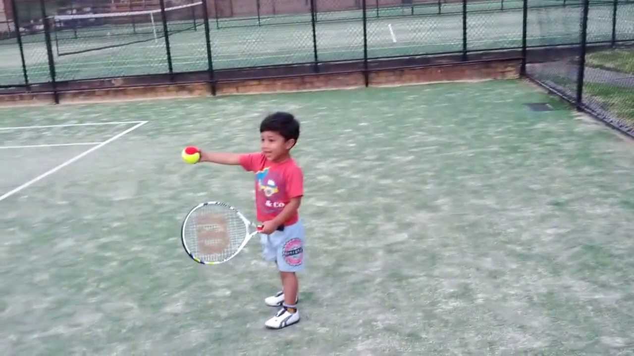 2 year old toddler playing tennis for the first time in his life