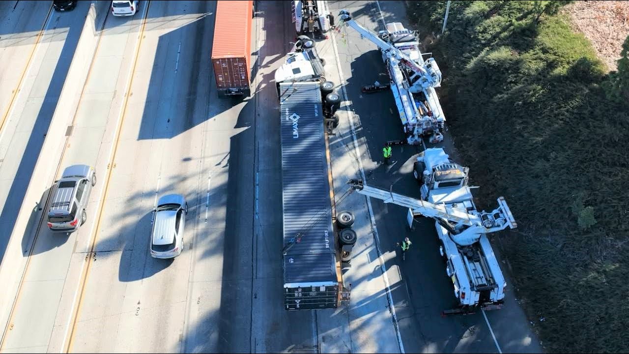 Rotators upright a container loaded with paint overturned on freeway