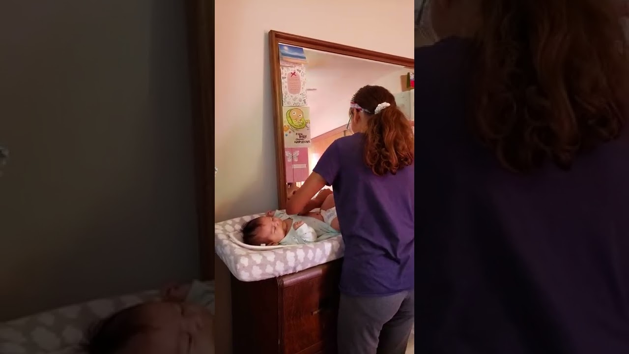 big sister changing little sister diaper.