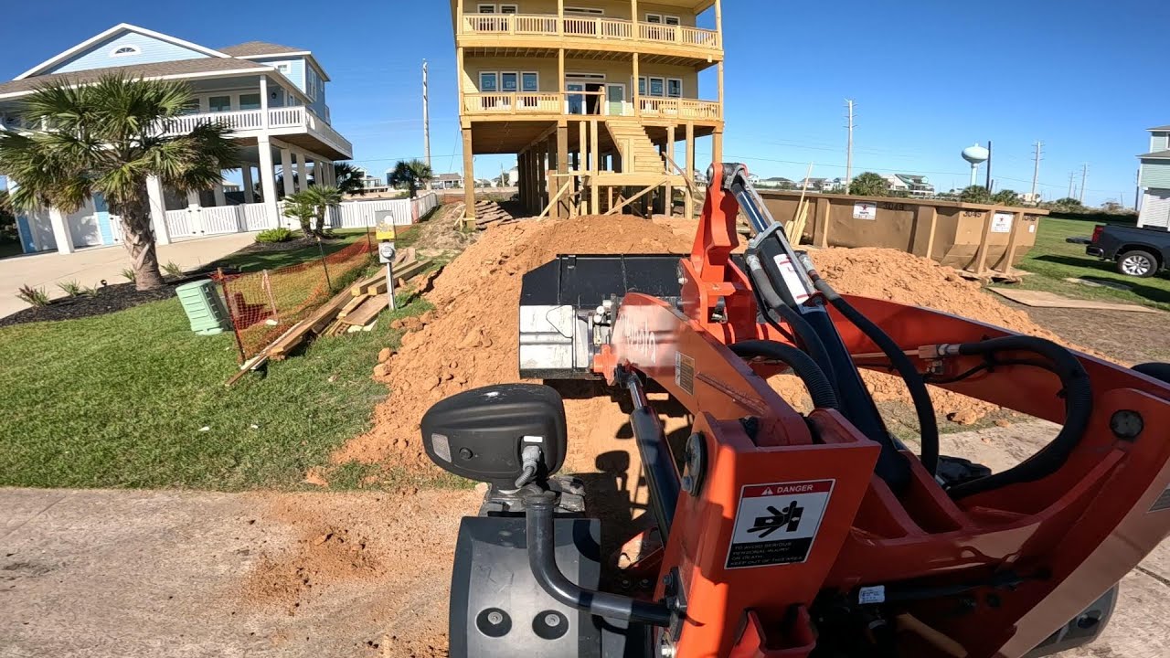 Loading dirt under an elevated house on Galveston island