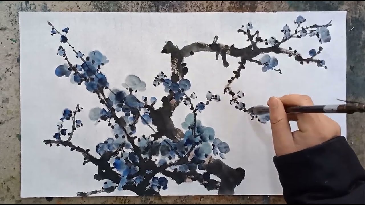 Художник рисует цветок сливы традиционной китайской кистью