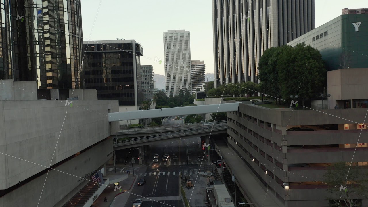 AERIAL: Epic flight through Downtown Los Angeles Skyscraper canyon in sunset light with car traffic