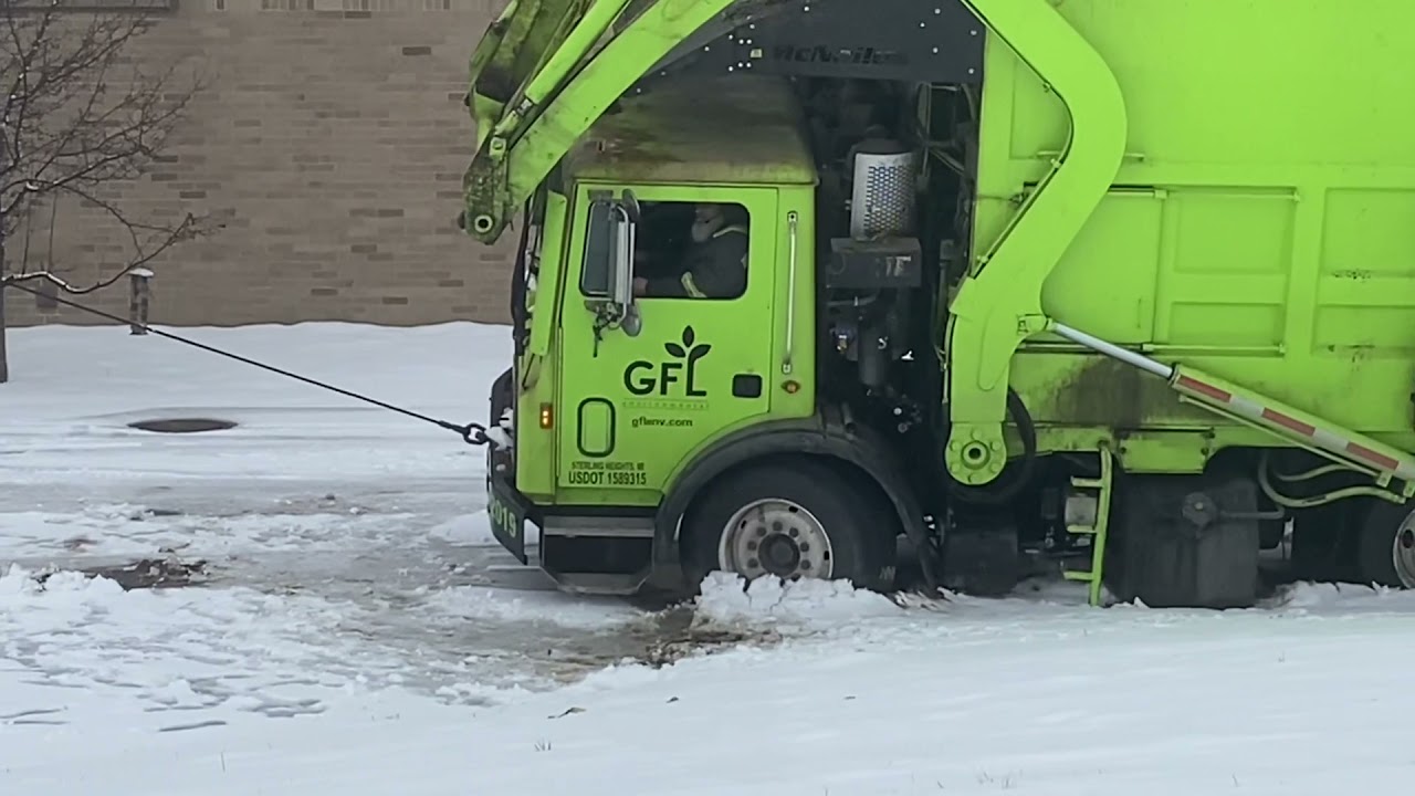 Heavy Duty Wrecker Recovery. Front Waste Hauler Dumpster Truck Stuck in Deep mud.