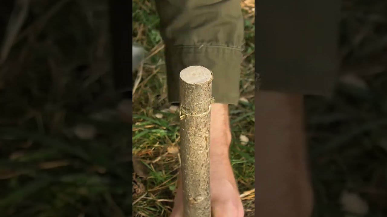 shaping a wooden stick with a metal pipe to make a connection point for outdoor camping equipment