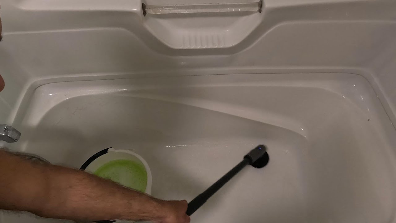 Using a HOTO Cordless Spin Scrubber to clean a bathtub with a build up of grime