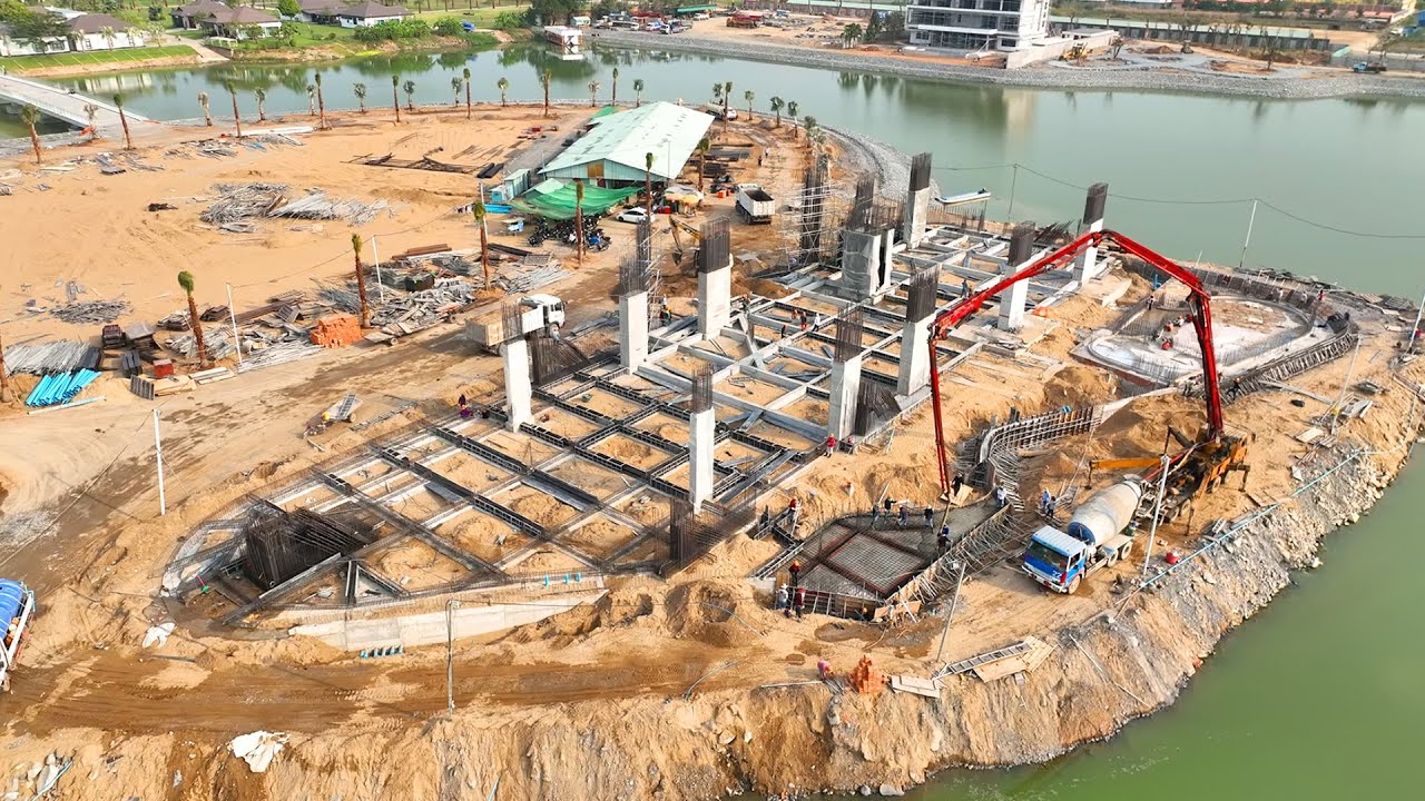 Trucks load large rocks into the lake and excavators dig up the rocks to make a footpath