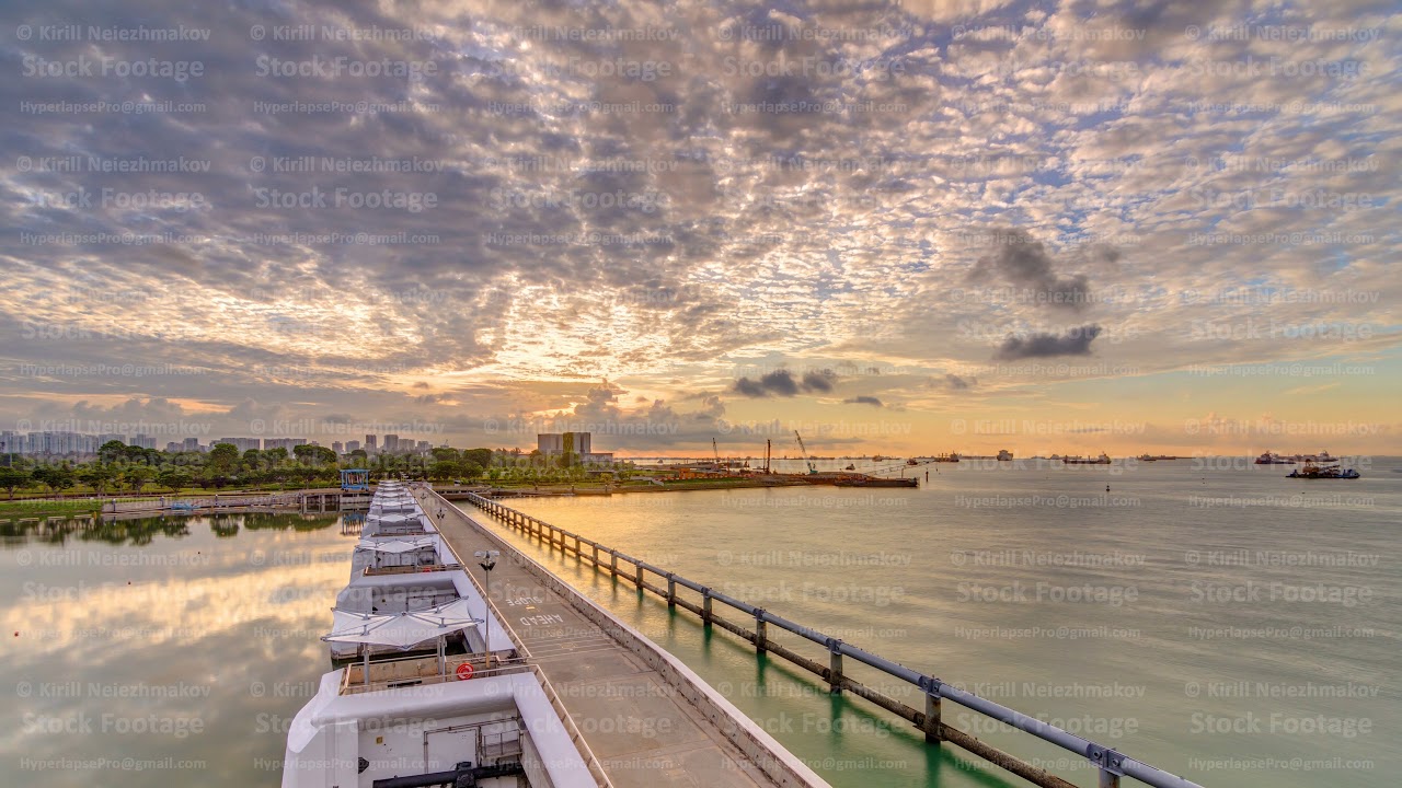 Beautiful sunrise scene at Marina Barrage timelapse. Orange sky and clouds with sun beams.