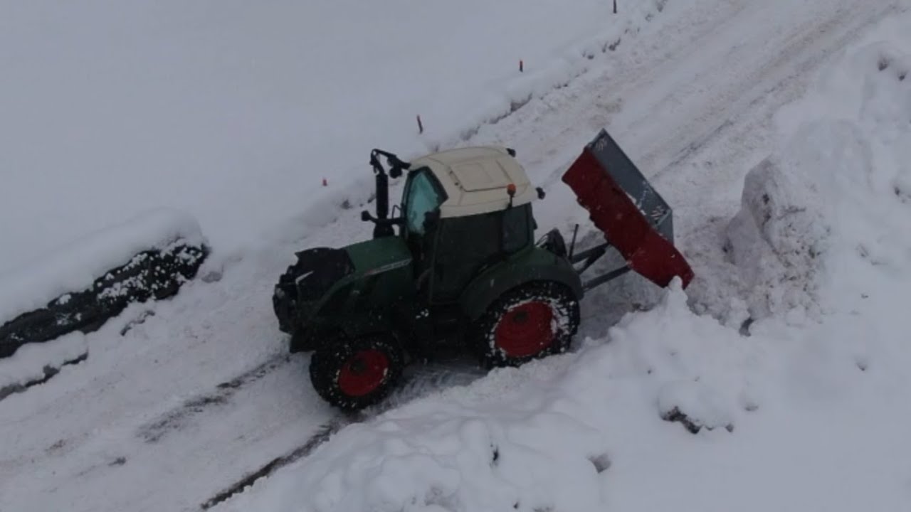 Ein Traktor, eine Schaufel, Schnee und eine Drohne   A tractor, shovel, snow and a high-flying drone