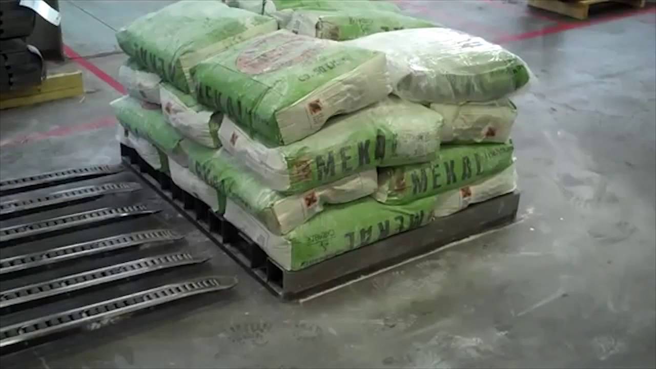 Estibado mecanizado de sacos de cemento sobre plataforma.
