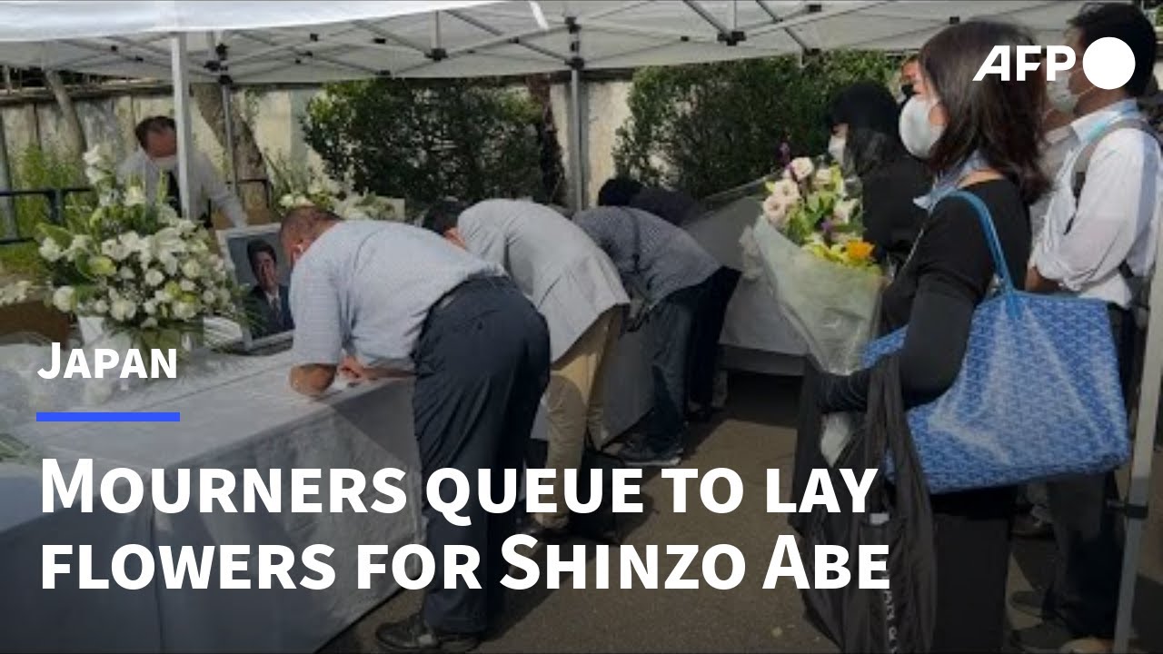 People line up to offer flowers for Abe outside party headquarters | AFP