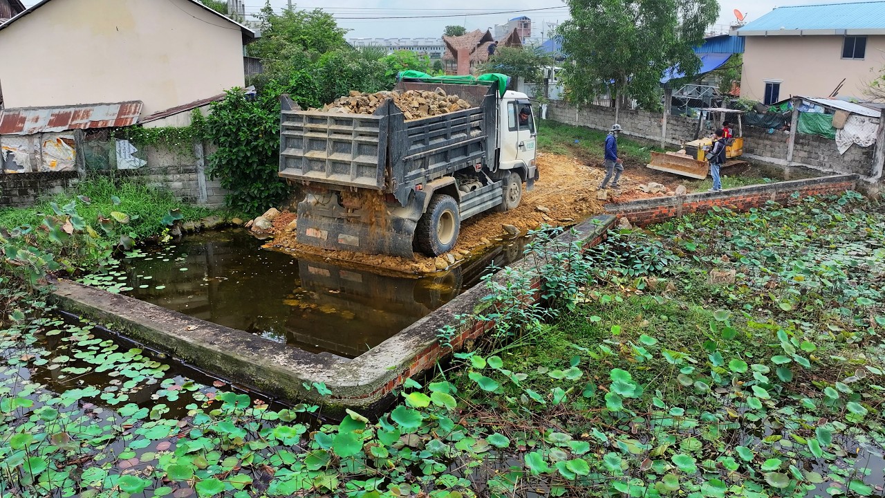 incredible delete pond landfill build factory , truck transport soil , bulldozer push soil to water