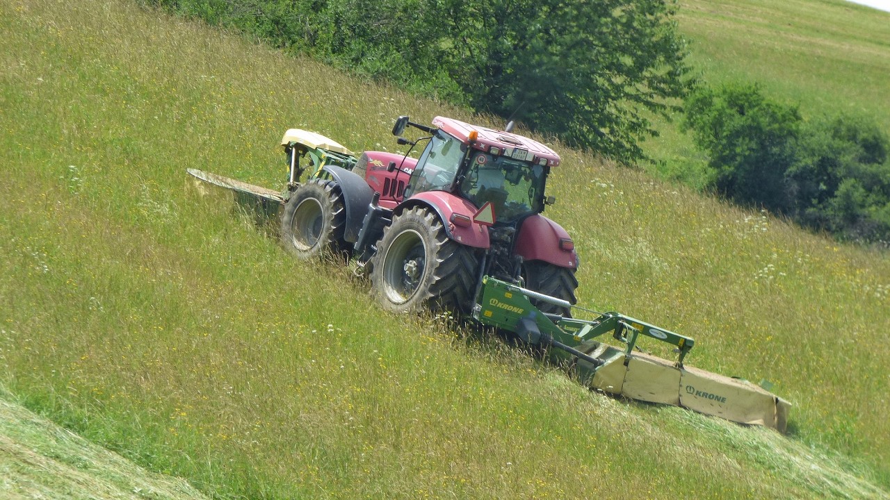 Скашивание и сгребание травы на склоне с помощью Case IH Puma 210, John Deere 8335 R и Krone [2024 ]