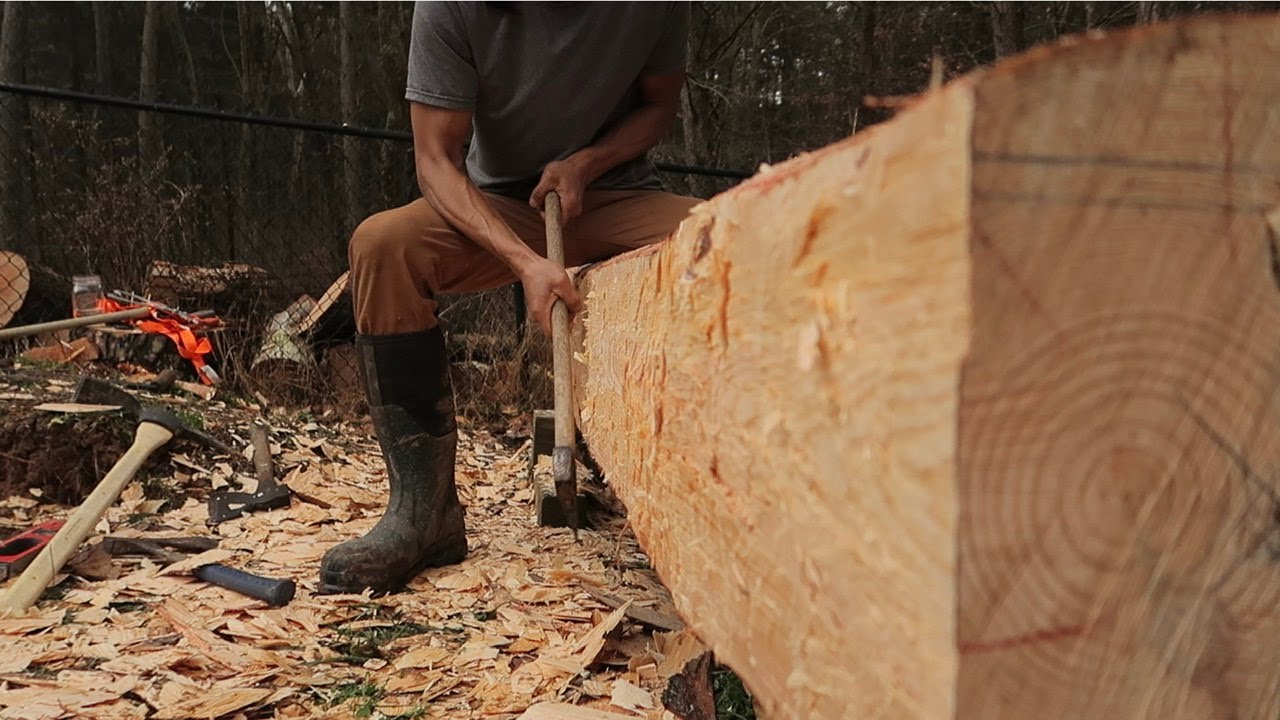 Hand hewing a log