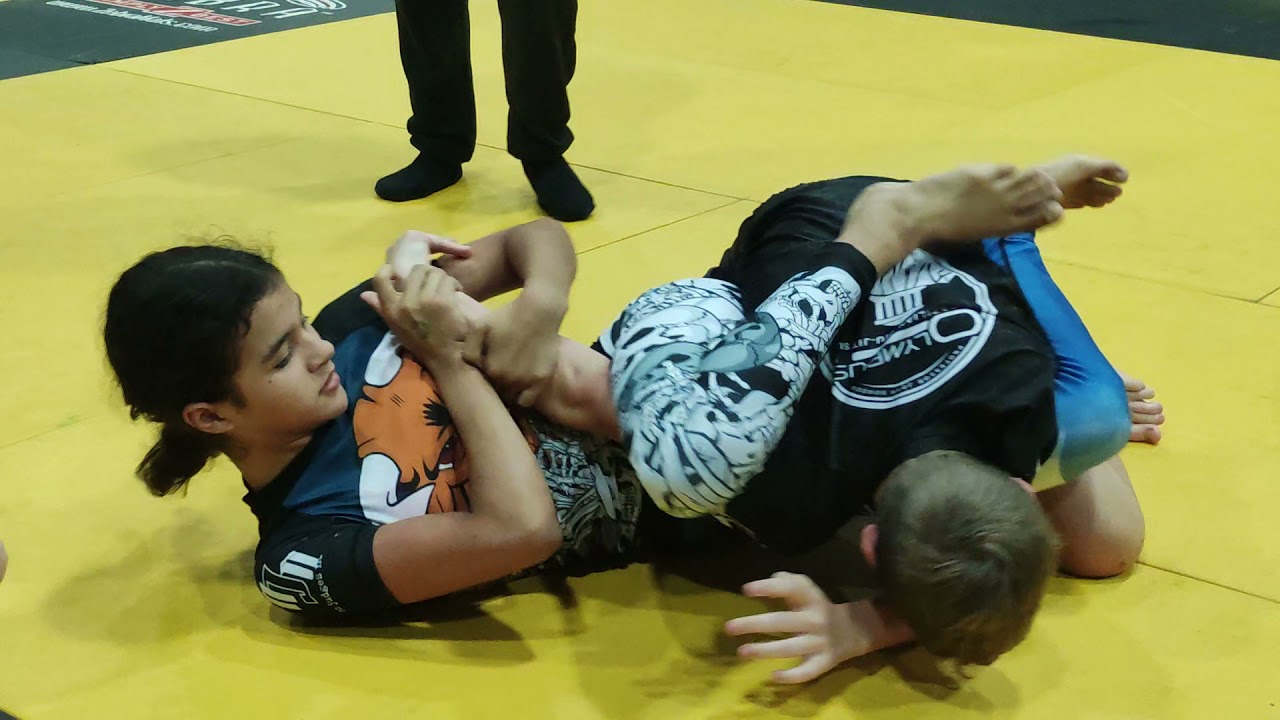 Brazilian Jiu-Jitsu girl vs boy battle for the arm. Girl Loses by 2 points but almost submits boy