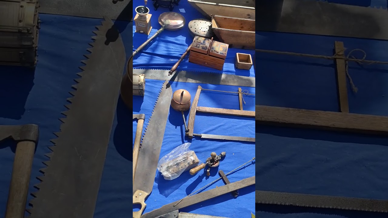 Old wheels, saws, axes at a flea market in Spain.  